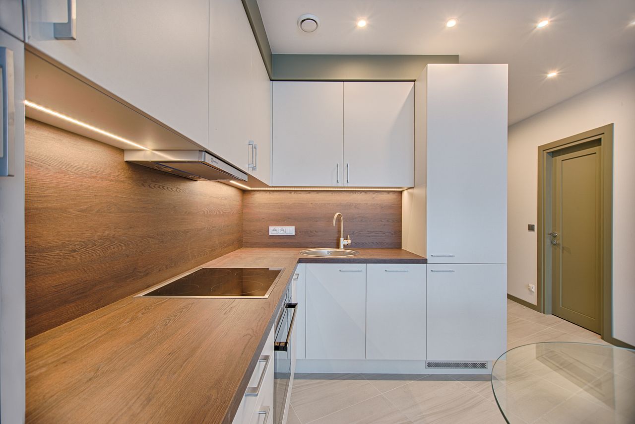 Modern kitchen interior with minimalistic design and wooden accents, captured with natural lighting